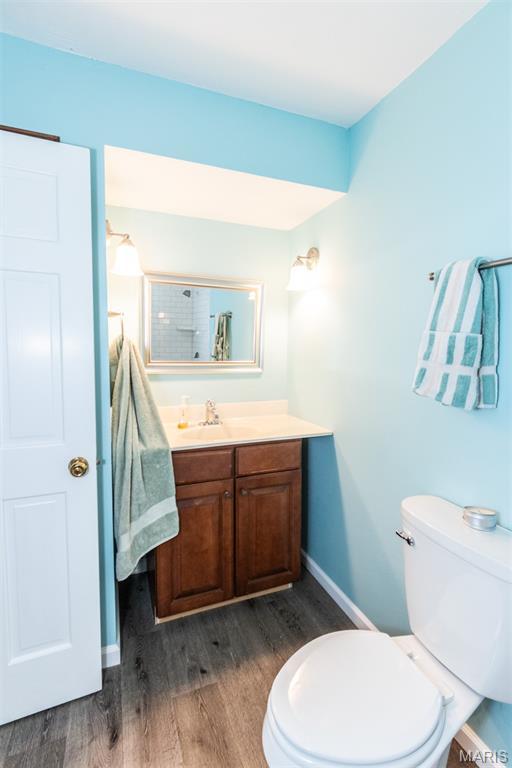 2915 Ozark Dr, Queeny Township, MO 63122 - bathroom featuring vanity, wood finished floors, toilet, and baseboards