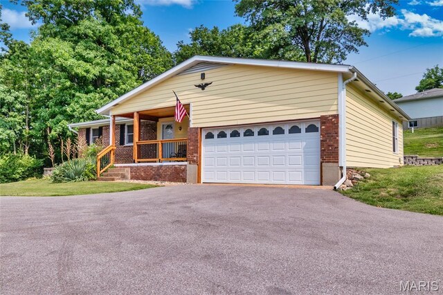 2915 Ozark Dr, Queeny Township, MO 63122 - ranch-style house featuring covered porch, driveway, a garage, and brick siding