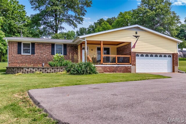 2915 Ozark Dr, Queeny Township, MO 63122 - ranch-style house featuring brick siding, covered porch, a front yard, and driveway