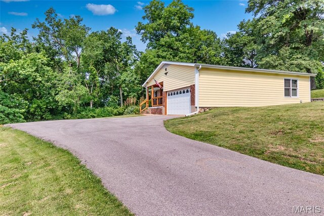 2915 Ozark Dr, Queeny Township, MO 63122 - view of property exterior featuring asphalt driveway, a lawn, and a garage