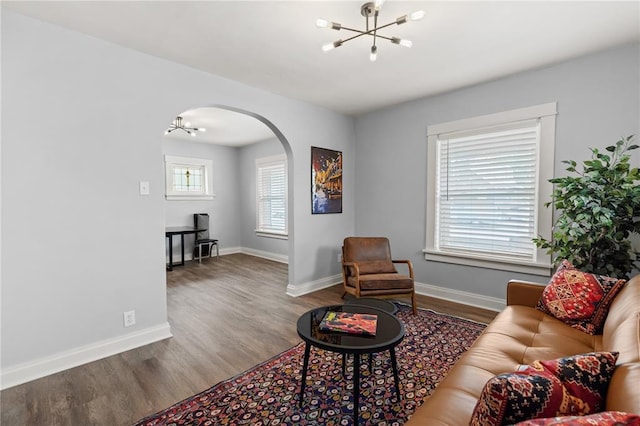 6927 Lansdowne Ave, Saint Louis, MO 63109 - living room featuring a chandelier, arched walkways, wood finished floors, and baseboards