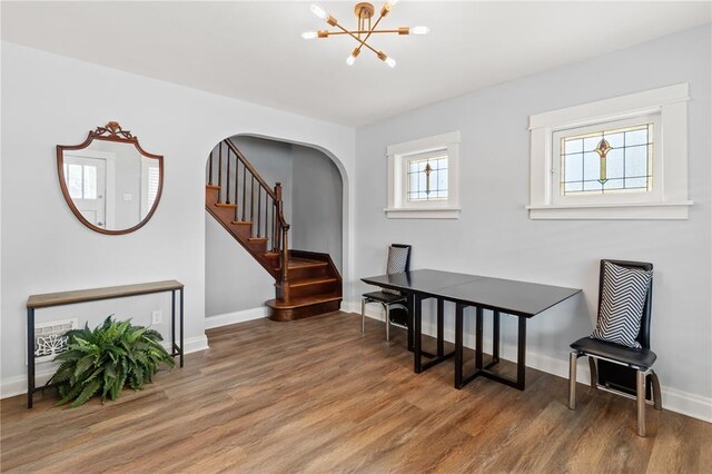 6927 Lansdowne Ave, Saint Louis, MO 63109 - dining room featuring a chandelier, wood finished floors, stairway, and arched walkways