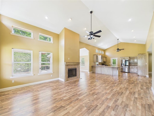 14800 County Road 448, St James, MO 65559 - unfurnished living room featuring high vaulted ceiling, a ceiling fan, light wood-style floors, a fireplace with flush hearth, and baseboards