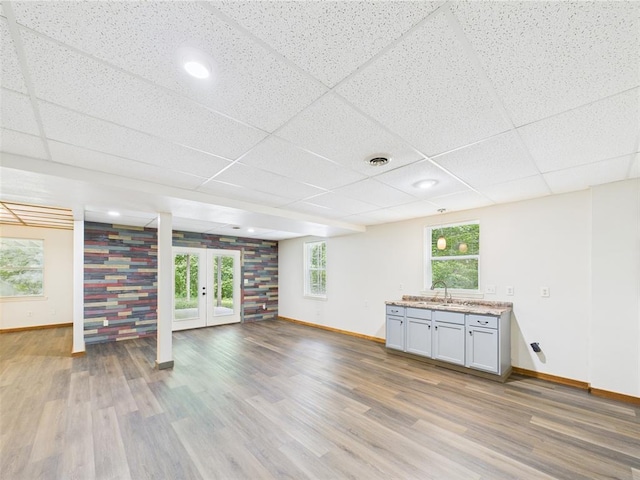 14800 County Road 448, St James, MO 65559 - unfurnished living room with baseboards, wood finished floors, french doors, a paneled ceiling, and a sink
