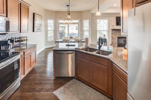 223 Ellington Ct, Glen Carbon, IL 62034 - kitchen featuring stainless steel appliances, a sink, dark wood-style flooring, brown cabinets, and stone countertops