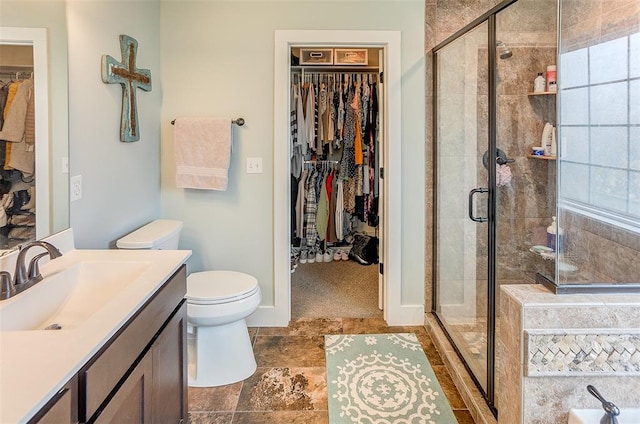 223 Ellington Ct, Glen Carbon, IL 62034 - bathroom featuring vanity, a spacious closet, toilet, a shower stall, and baseboards