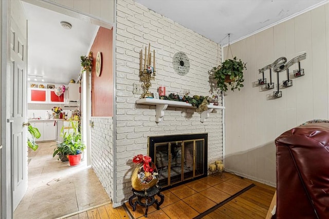 930 Laredo Ave, Saint Louis, MO 63138 - living room with hardwood / wood-style flooring, a brick fireplace, wooden walls, and ornamental molding