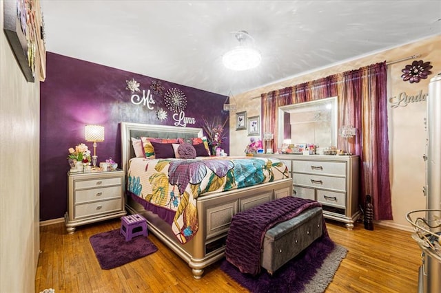 930 Laredo Ave, Saint Louis, MO 63138 - bedroom with baseboards, wood finished floors, an accent wall, and wallpapered walls