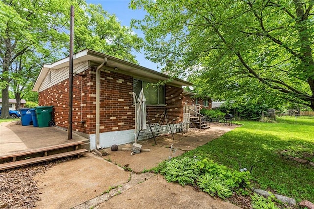 930 Laredo Ave, Saint Louis, MO 63138 - view of property exterior featuring brick siding, a deck, a lawn, and entry steps