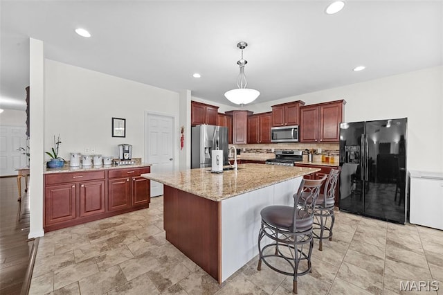 38 Crystal Manor Ct, Wentzville, MO 63385 - kitchen featuring appliances with stainless steel finishes, hanging light fixtures, a breakfast bar area, light stone counters, and a sink