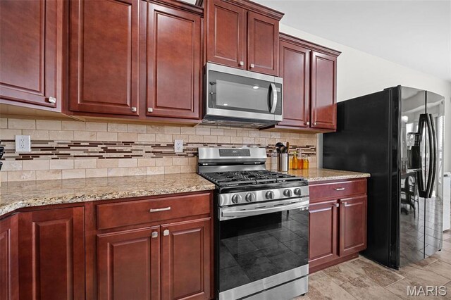 38 Crystal Manor Ct, Wentzville, MO 63385 - kitchen with stainless steel appliances, dark brown cabinets, and light stone counters