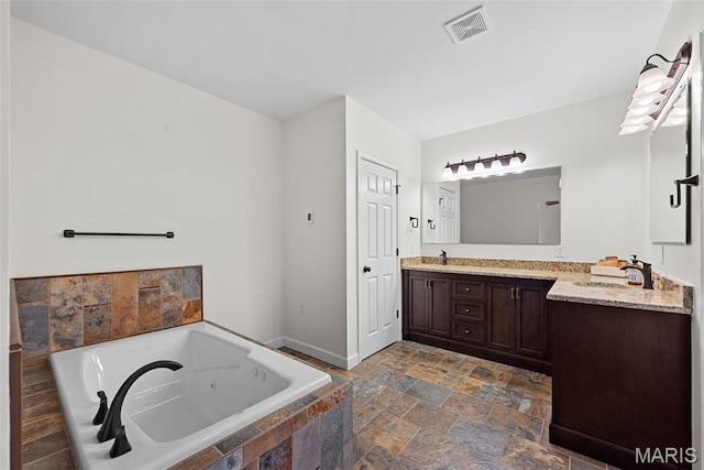 38 Crystal Manor Ct, Wentzville, MO 63385 - full bathroom featuring double vanity, a jetted tub, stone finish flooring, and baseboards