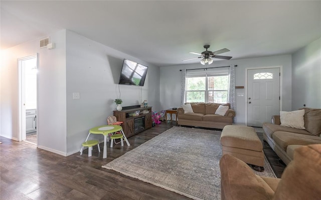 20336 Scholar Ln, Waynesville, MO 65583 - living area with dark wood-style floors, ceiling fan, baseboards, and a glass covered fireplace