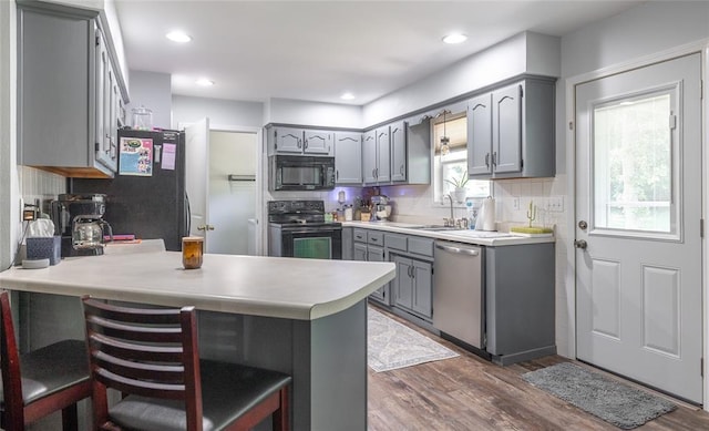 20336 Scholar Ln, Waynesville, MO 65583 - kitchen with black appliances, gray cabinets, a peninsula, a sink, and dark wood-type flooring