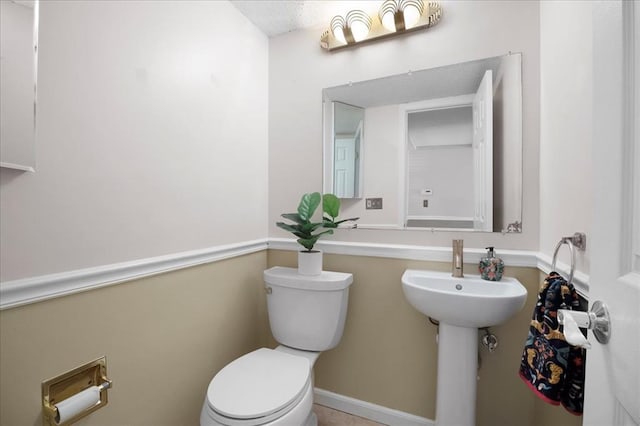 11846 Sologne Ct, Maryland Heights, MO 63043 - half bathroom with toilet, a sink, and a textured ceiling