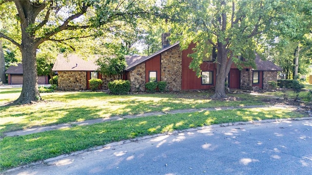 22 Greenbriar Dr, New Madrid, MO 63869 - view of front of home featuring stone siding, a front lawn, and a chimney