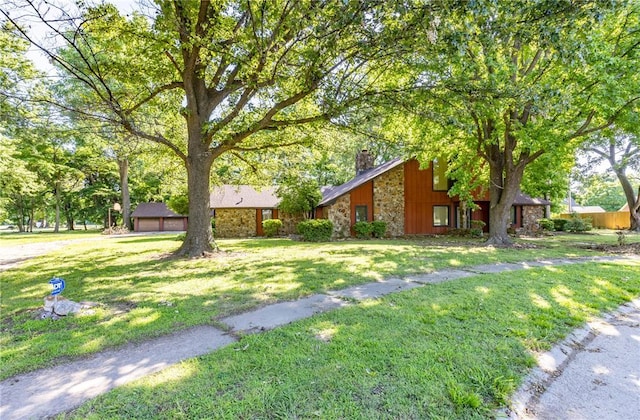 22 Greenbriar Dr, New Madrid, MO 63869 - view of side of property featuring a chimney, stone siding, and a yard