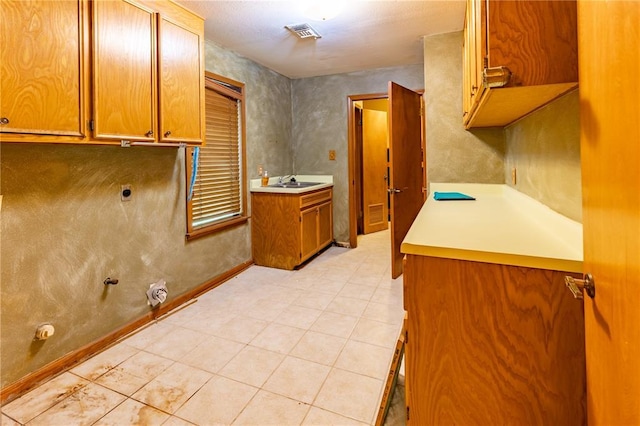 22 Greenbriar Dr, New Madrid, MO 63869 - laundry room featuring cabinet space, gas dryer hookup, light tile patterned floors, baseboards, and hookup for an electric dryer