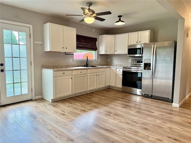 7729 Humbert Rd, Godfrey, IL 62035 - kitchen featuring appliances with stainless steel finishes, ceiling fan, a sink, white cabinets, and light wood-style flooring