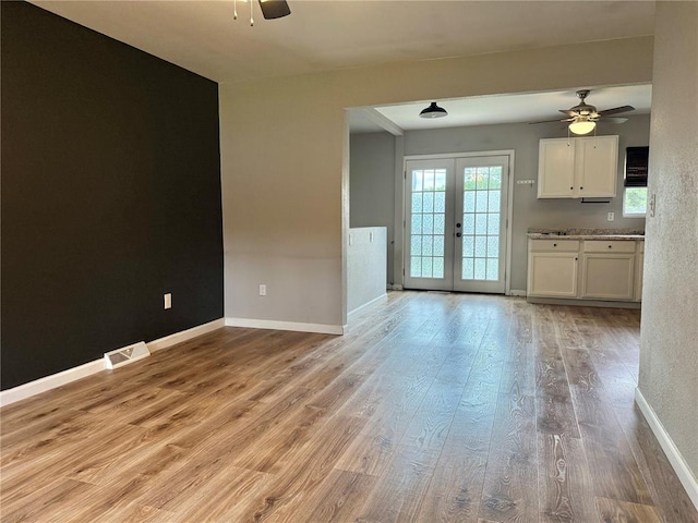 7729 Humbert Rd, Godfrey, IL 62035 - unfurnished living room with ceiling fan, light wood finished floors, french doors, and baseboards