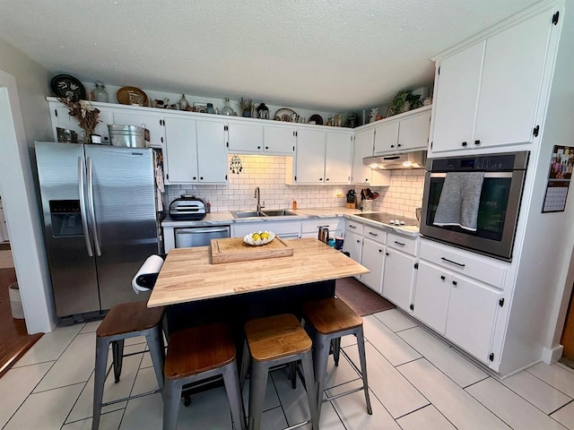 11181 Shady Ln, Dexter, MO 63841 - kitchen with stainless steel appliances, a sink, tasteful backsplash, light countertops, and white cabinets