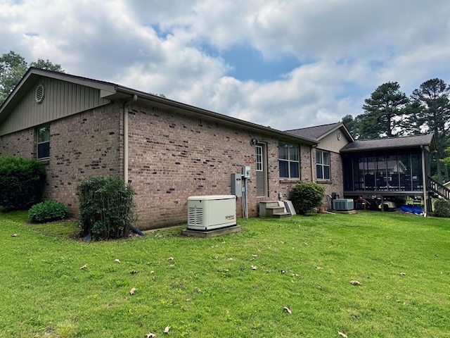 11181 Shady Ln, Dexter, MO 63841 - rear view of house with a sunroom, brick siding, a lawn, and central AC unit