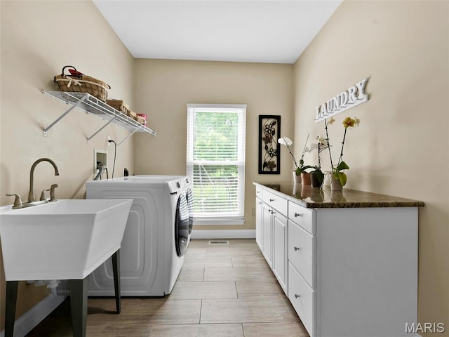 1165 Nooning Tree Dr, Chesterfield, MO 63017 - washroom featuring independent washer and dryer, cabinet space, and light wood-style flooring