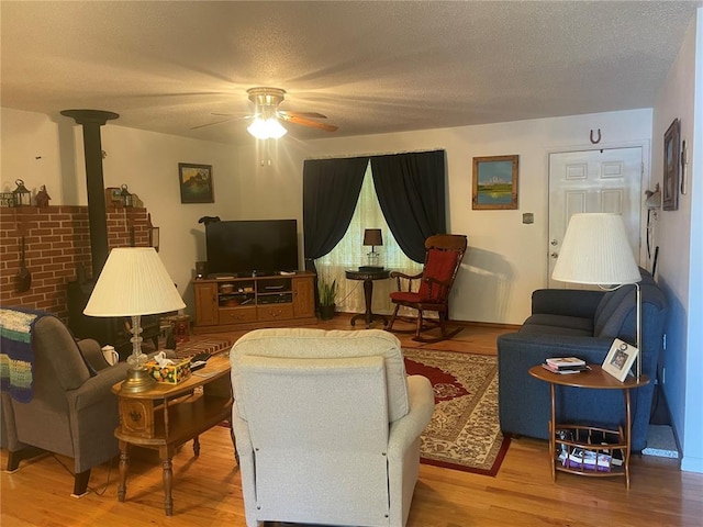 95 W Lakeview Dr, De Soto, MO 63020 - living area with wood finished floors, a ceiling fan, a textured ceiling, and a wood stove