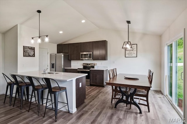800 Boulder Crest Ct, Eureka, MO 63025 - kitchen featuring stainless steel appliances, vaulted ceiling, a sink, a breakfast bar, and dark brown cabinetry