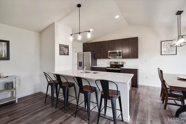 800 Boulder Crest Ct, Eureka, MO 63025 - kitchen featuring stainless steel appliances, a sink, dark brown cabinetry, a kitchen bar, and vaulted ceiling