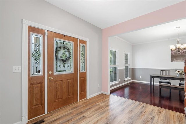 3912 Jacobs Lndg, Saint Charles, MO 63304 - entrance foyer with a chandelier, wood finished floors, baseboards, and crown molding