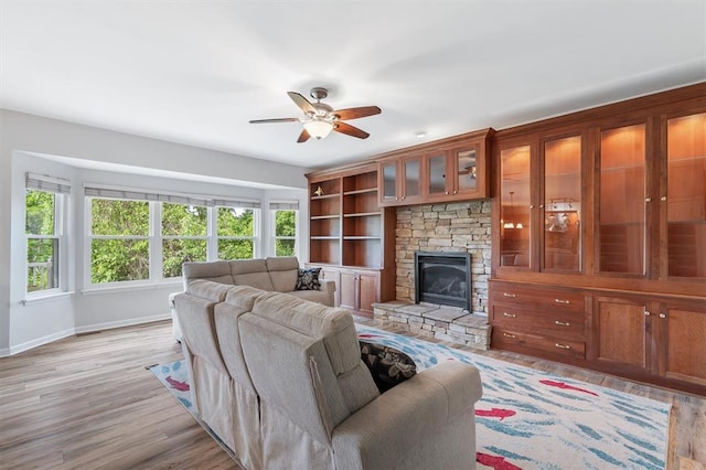 3912 Jacobs Lndg, Saint Charles, MO 63304 - living area with ceiling fan, light wood-style floors, baseboards, and a stone fireplace