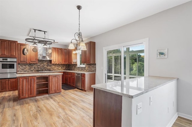 3912 Jacobs Lndg, Saint Charles, MO 63304 - kitchen with stainless steel appliances, a warming drawer, backsplash, wall chimney range hood, and light wood-type flooring