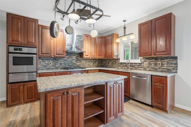 3912 Jacobs Lndg, Saint Charles, MO 63304 - kitchen featuring stainless steel appliances, a warming drawer, wall chimney exhaust hood, a sink, and light wood-style floors