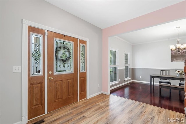3912 Jacobs Lndg, Saint Charles, MO 63304 - foyer with a chandelier, wood finished floors, baseboards, and crown molding