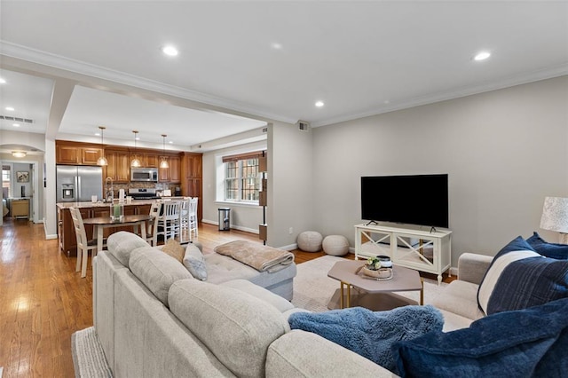 7520 Buckingham Dr Unit 1W, Saint Louis, MO 63105 - living room with light wood-style floors, baseboards, recessed lighting, ornamental molding, and arched walkways