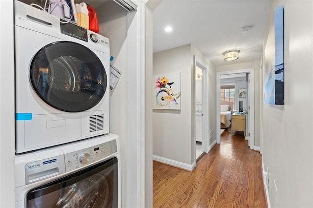 7520 Buckingham Dr Unit 1W, Saint Louis, MO 63105 - washroom featuring estacked washer and dryer, light wood-style flooring, baseboards, and recessed lighting