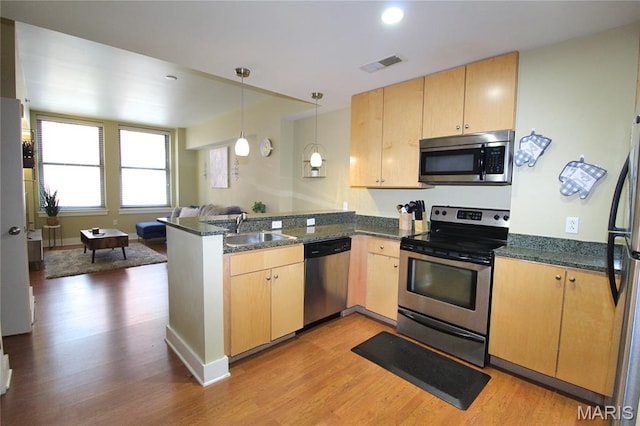 314 N Broadway Unit 603, Saint Louis, MO 63102 - kitchen featuring stainless steel appliances, a peninsula, light brown cabinets, light wood finished floors, and recessed lighting