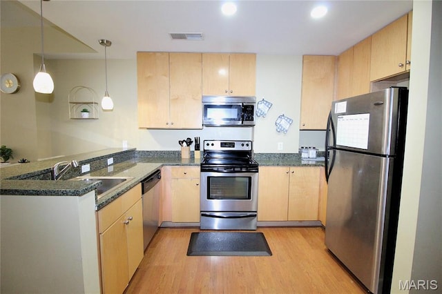 314 N Broadway Unit 603, Saint Louis, MO 63102 - kitchen with appliances with stainless steel finishes, light brown cabinetry, a peninsula, light wood-style floors, and dark stone counters