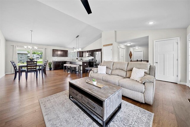 217 Arlington Dr, Moscow Mills, MO 63362 - living room featuring a chandelier, lofted ceiling, wood finished floors, and baseboards