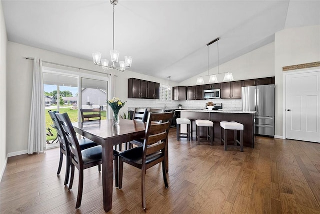 217 Arlington Dr, Moscow Mills, MO 63362 - dining space with lofted ceiling, a chandelier, and dark wood finished floors