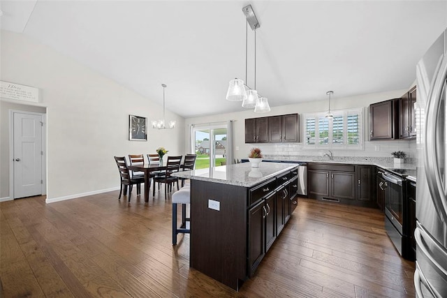 217 Arlington Dr, Moscow Mills, MO 63362 - kitchen featuring stainless steel appliances, vaulted ceiling, dark brown cabinetry, a center island, and a breakfast bar