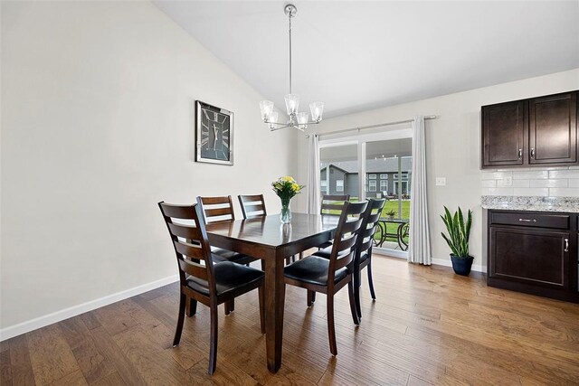 217 Arlington Dr, Moscow Mills, MO 63362 - dining room with a chandelier, baseboards, wood finished floors, and vaulted ceiling