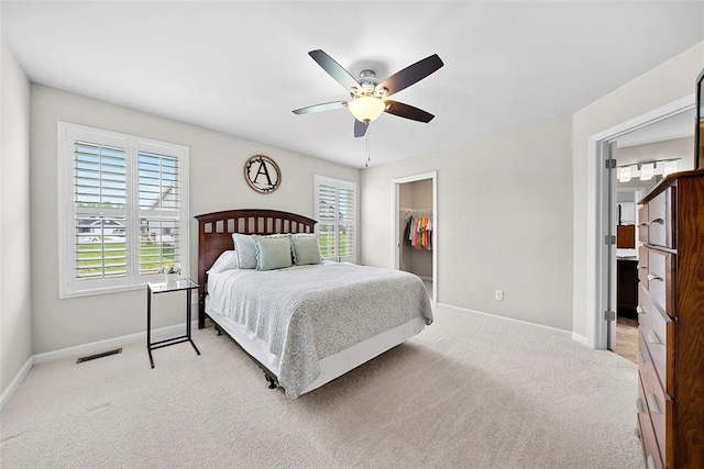 217 Arlington Dr, Moscow Mills, MO 63362 - bedroom with baseboards, a walk in closet, light carpet, a closet, and ceiling fan