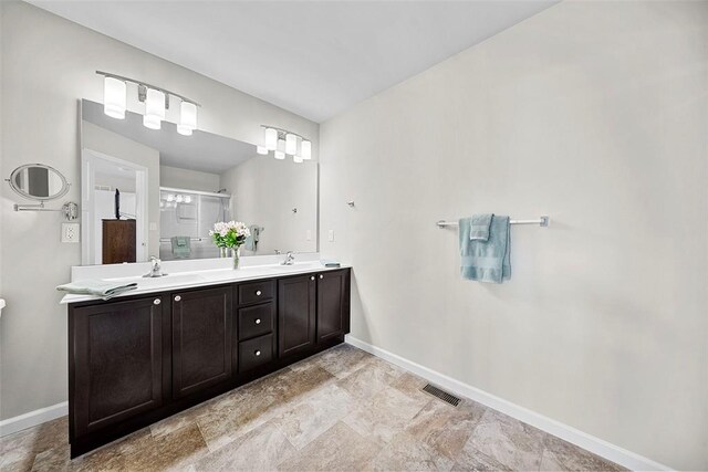217 Arlington Dr, Moscow Mills, MO 63362 - bathroom featuring baseboards, double vanity, a shower stall, and stone finish flooring