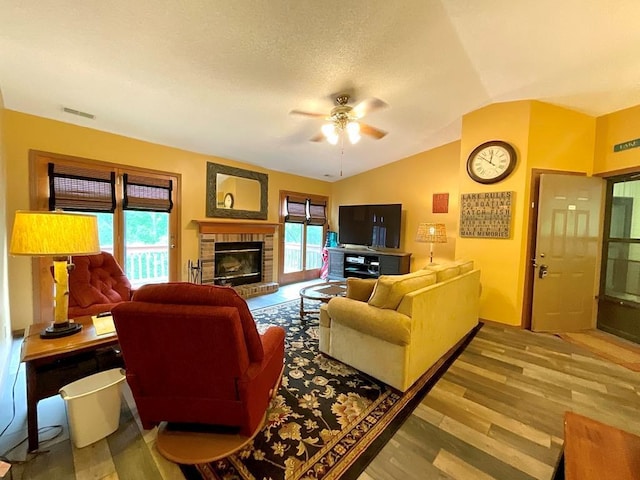 18318 Lakeview Cir Unit 606, Monroe City, MO 63456 - living area with ceiling fan, vaulted ceiling, wood finished floors, a brick fireplace, and a textured ceiling