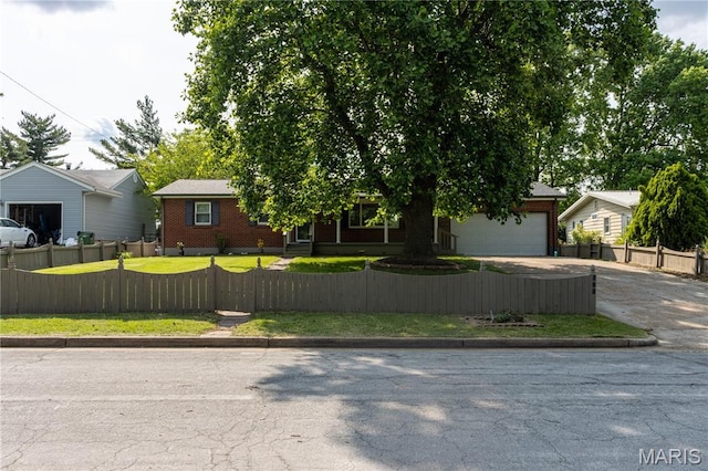 811 Bray Ave, Rolla, MO 65401 - view of front facade with a fenced front yard, concrete driveway, a garage, and brick siding
