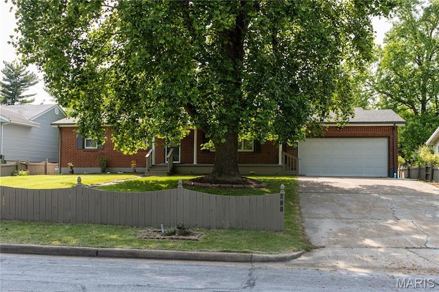 811 Bray Ave, Rolla, MO 65401 - view of property hidden behind natural elements featuring an attached garage, a fenced front yard, driveway, and brick siding