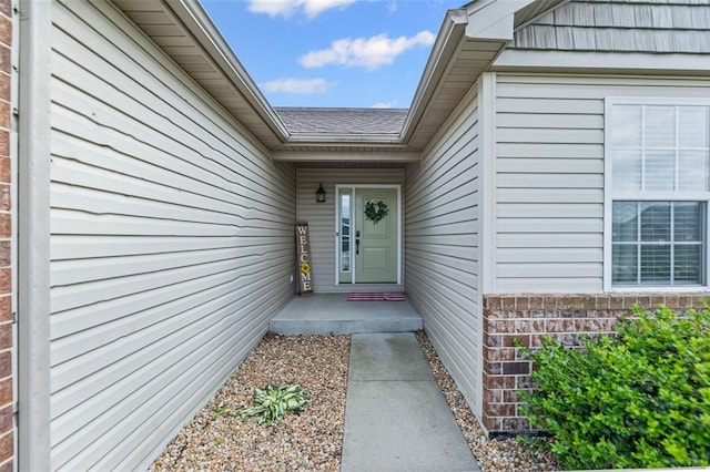 view of exterior entry with brick siding
