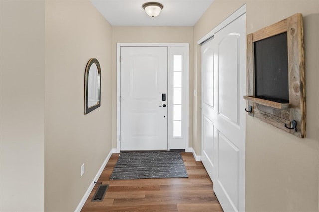 foyer featuring baseboards and wood finished floors